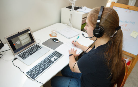 A girl with a headset using her laptop