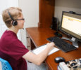 A boy with a headset sitting at the computer