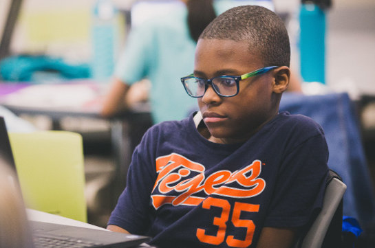A boy at a desk with his laptop
