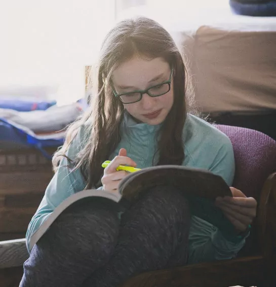 A girl highlighting a workbook