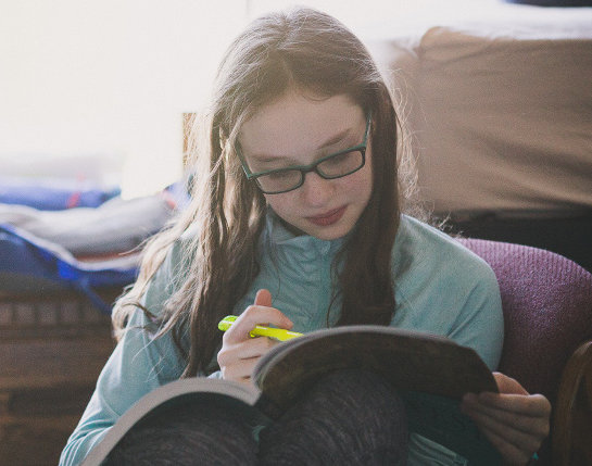 A girl highlighting a workbook