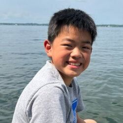 Boy smiling with a lake in the background