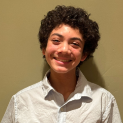 Teenage boy smiling in front of an interior wall