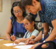 Girl and parents working on an art project together